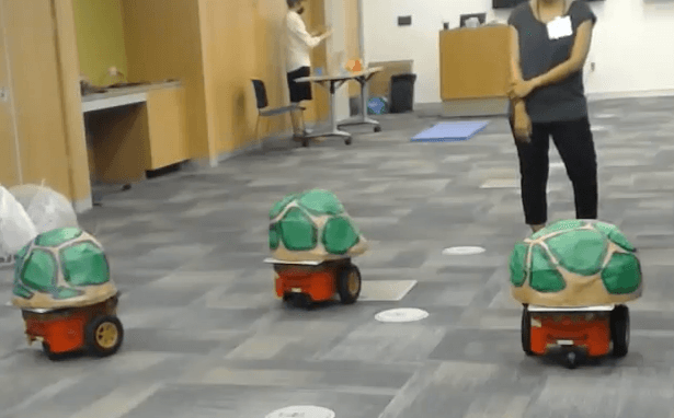 Three turtle-shaped robots approaching a participant in the wedge condition of the Social Triangles study